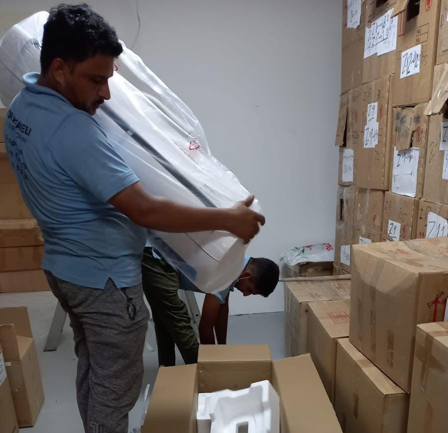 Noor Al Fareej technicians unpacking new split AC units for installation in Sharjah