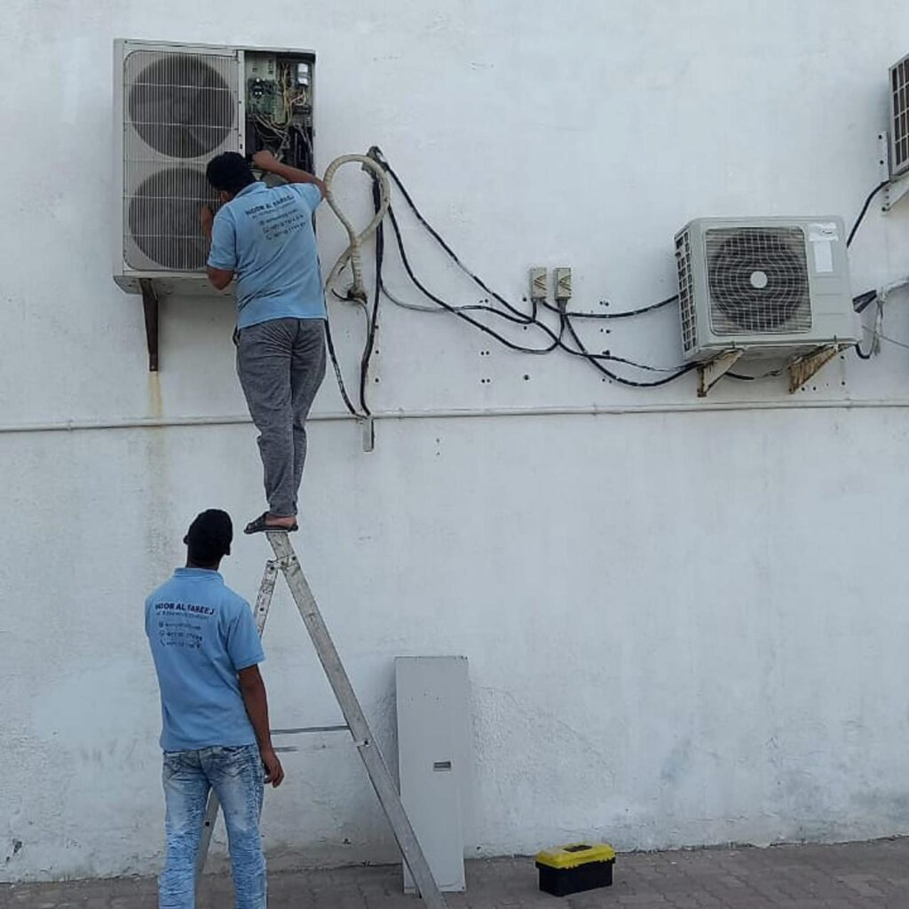 Air conditioning technician using diagnostic tools to repair a commercial AC unit