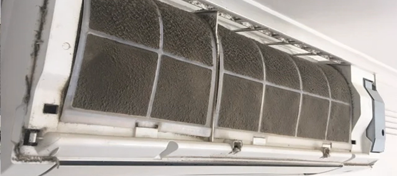 Dirty AC Filter – Importance of Regular Air Conditioner Cleaning Close-up of a dirty and clogged air conditioner filter in need of cleaning